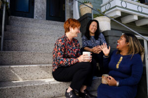Tina and her friends Melissa and Erika talking on a stoop.